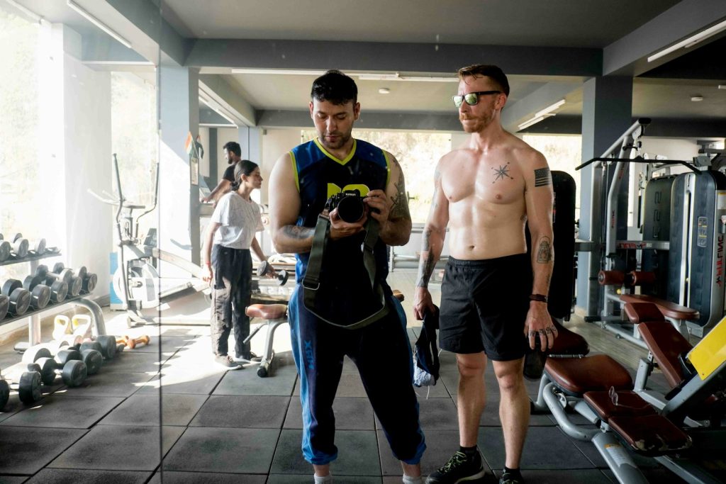 a couple of men standing next to each other in a gym