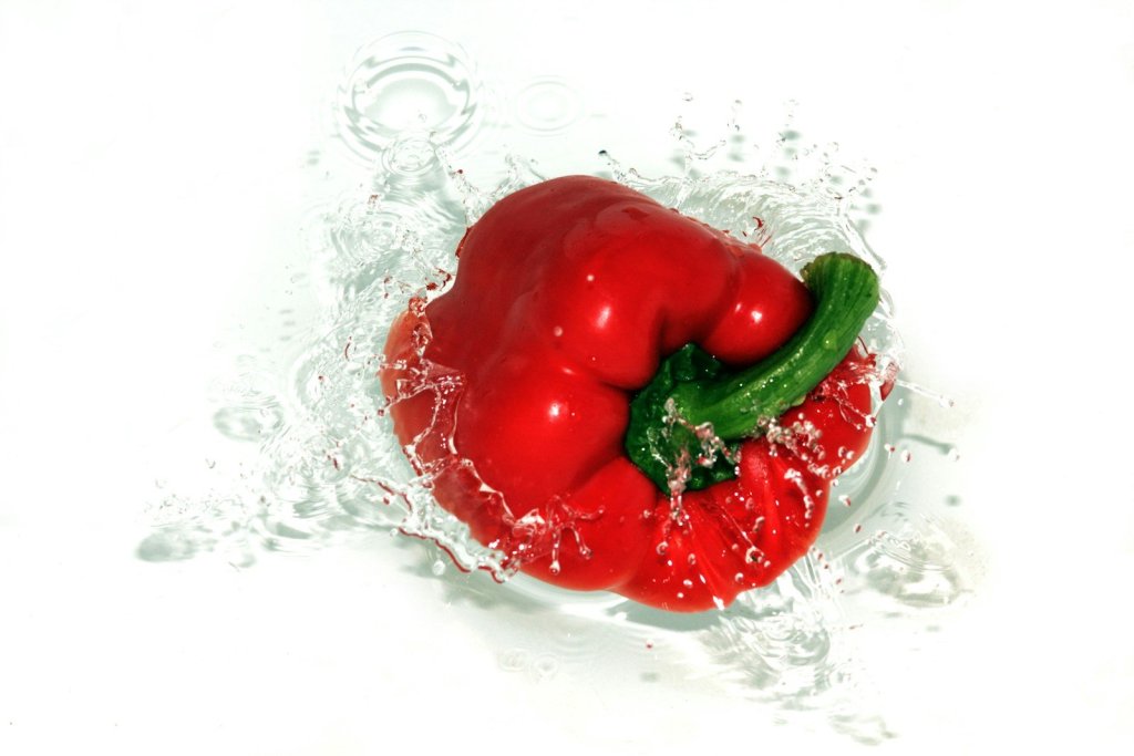 a red pepper with a green pepper on top of it