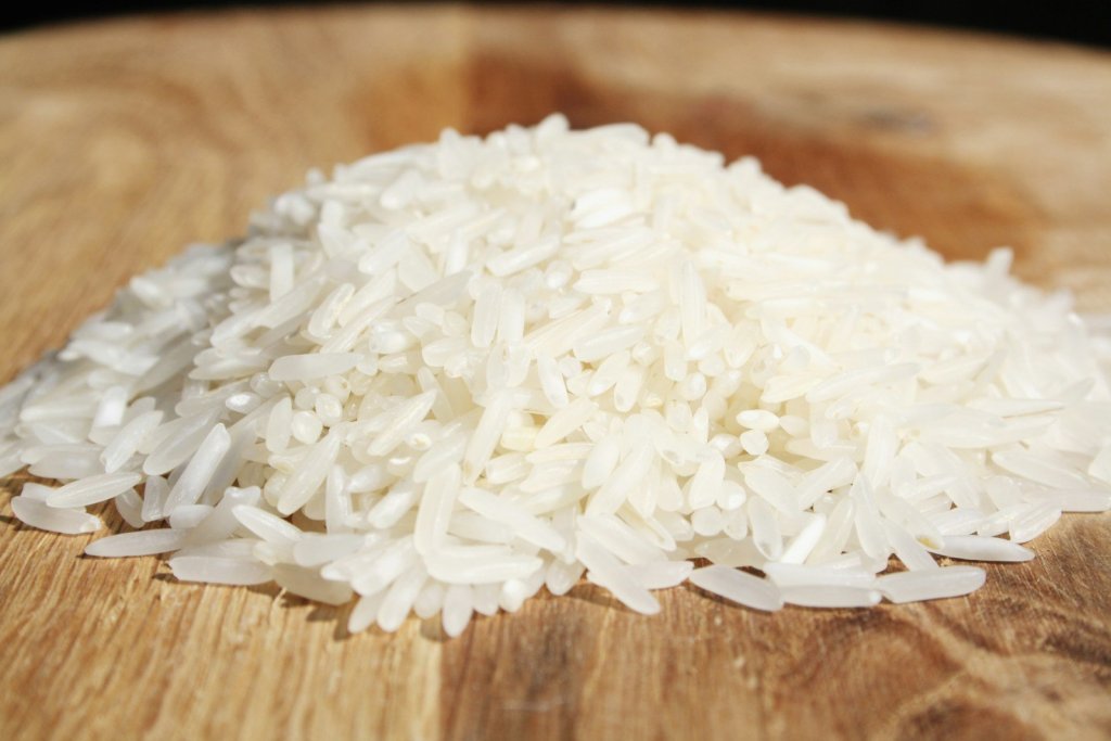 A pile of rice sitting on top of a wooden cutting board