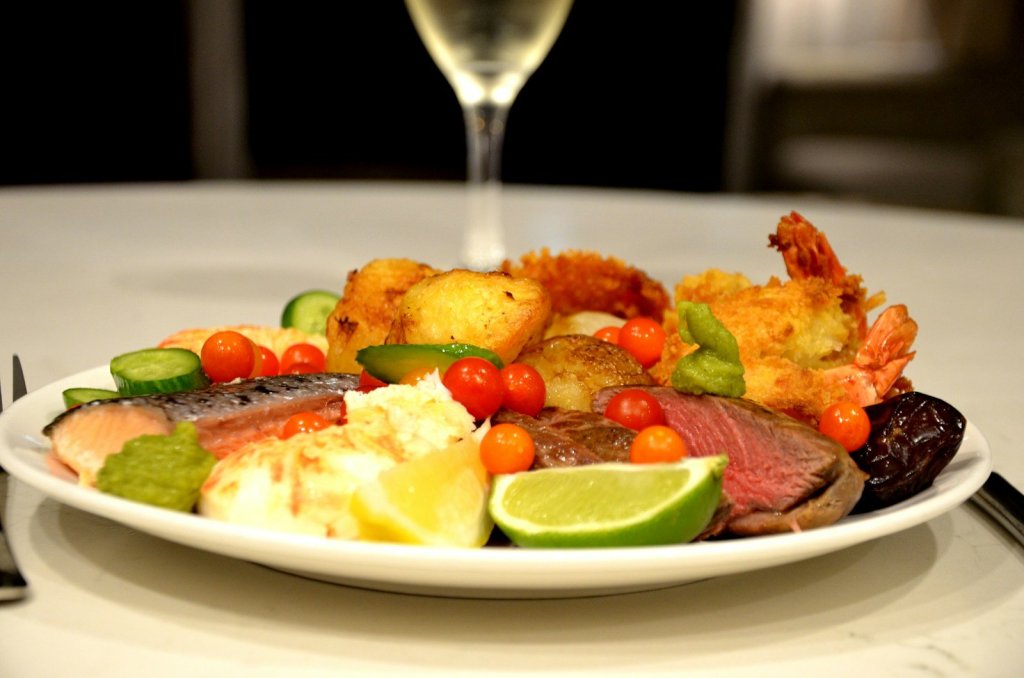 A plate of food and a glass of wine on a table